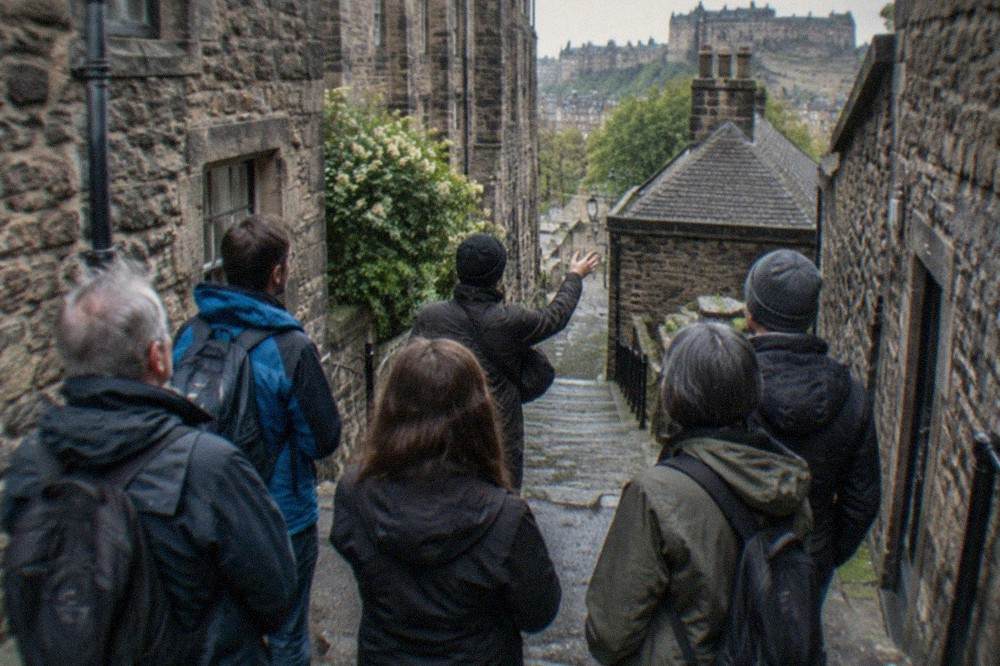 Old stone alleyway in Edinburgh's Old Town with worn steps between tenement walls