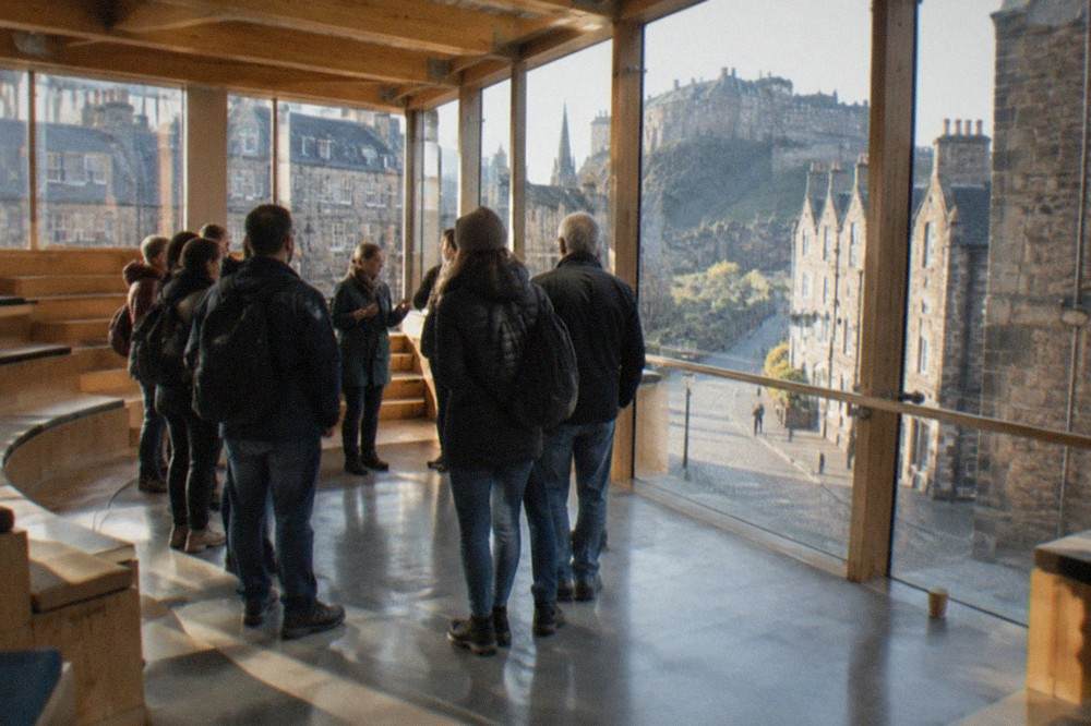 The debating chamber of the Scottish Parliament with curved seating and exposed oak beams