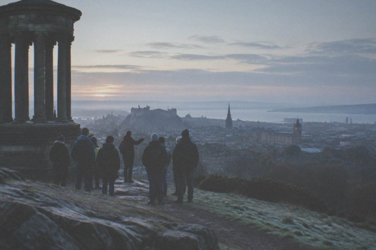 View of Edinburgh skyline from Calton Hill with the Dugald Stewart Monument in the foreground and the city stretching toward the Firth of Forth.