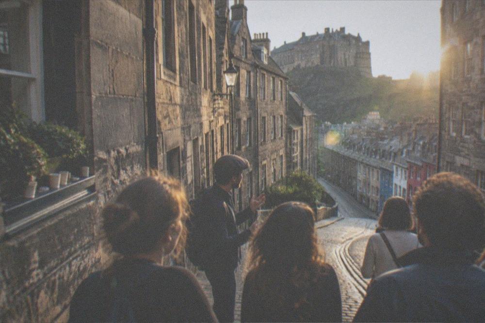 A festival crowd gathered on an Edinburgh street in evening light