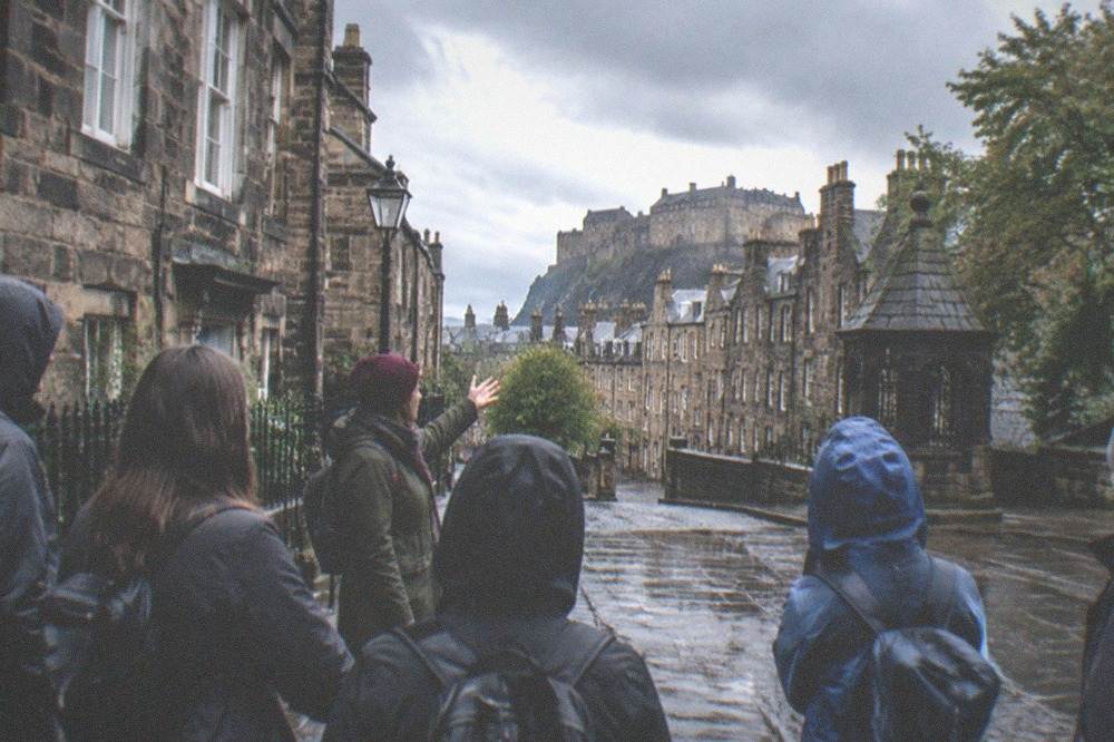 View over Edinburgh city rooftops from a gallery window with rain clouds