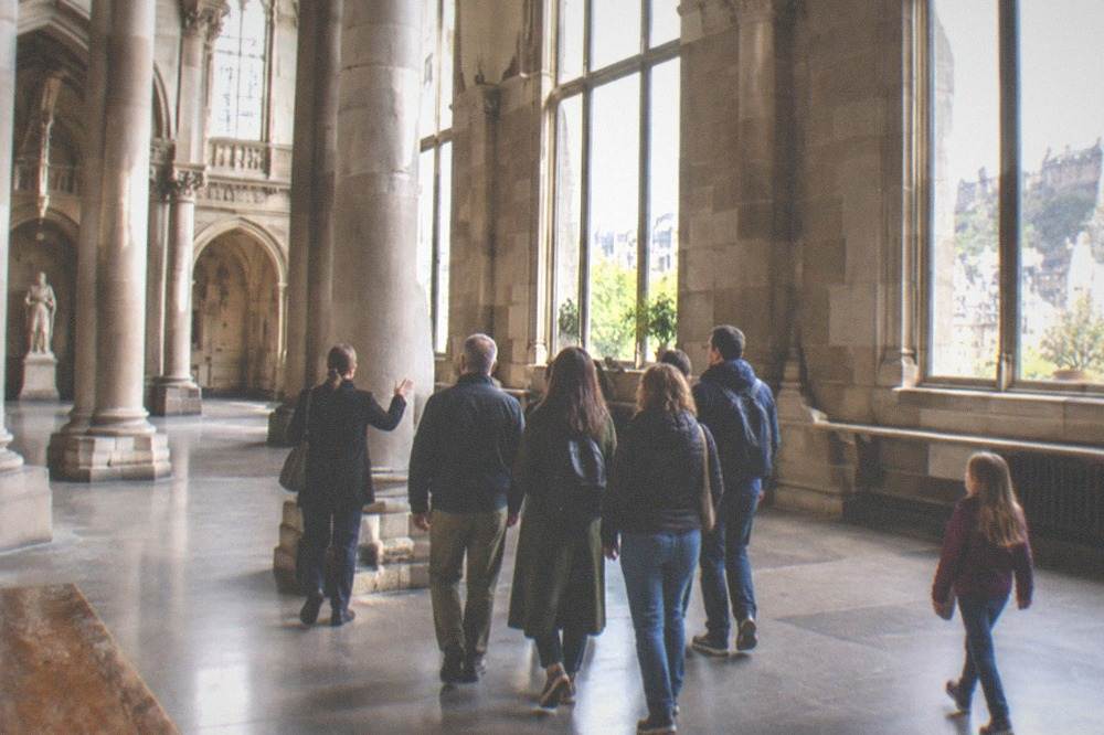 A museum gallery hall with tall stone columns and natural light