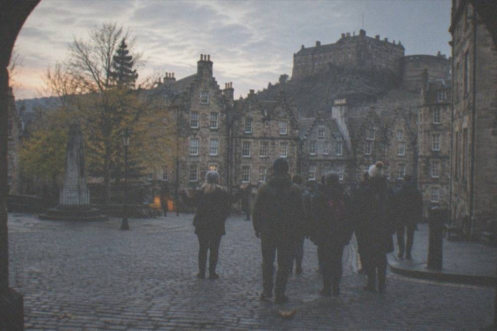 The Grassmarket at dusk with the castle rock rising behind the buildings