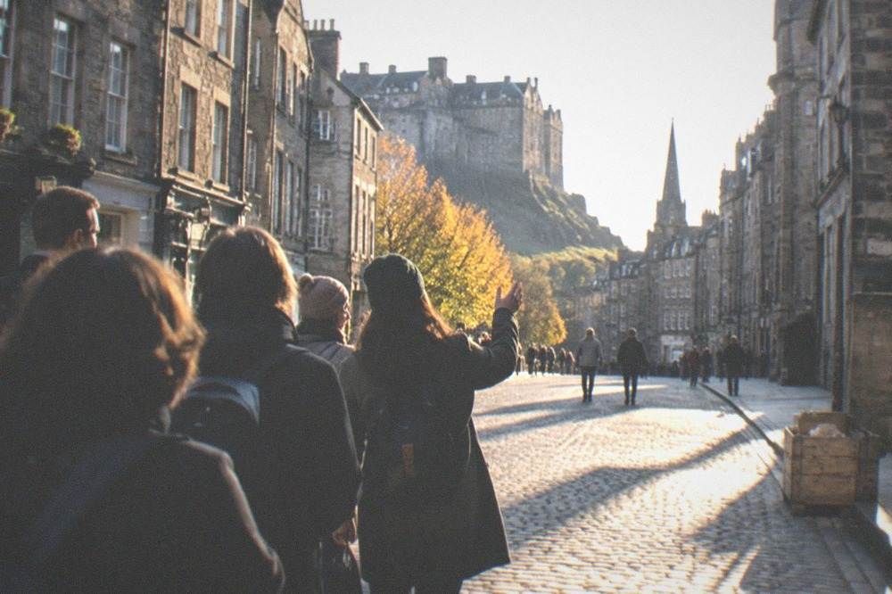 The wide cobbled Royal Mile in Edinburgh lined with tall grey stone buildings