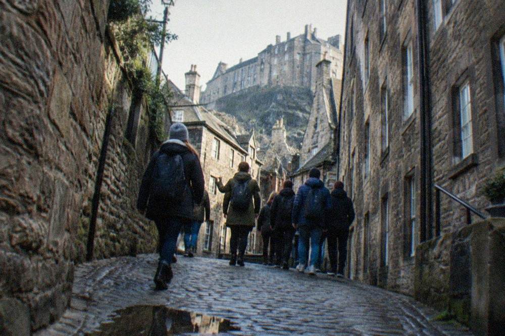 Narrow cobblestone close between tall old stone buildings on the Royal Mile