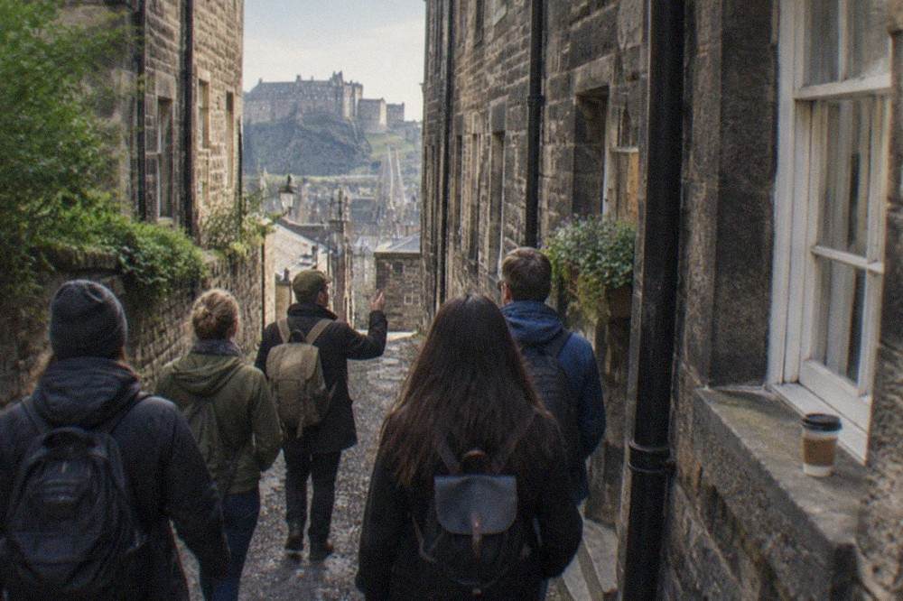 A narrow stone close in Edinburgh's Old Town with tall tenement walls rising on both sides