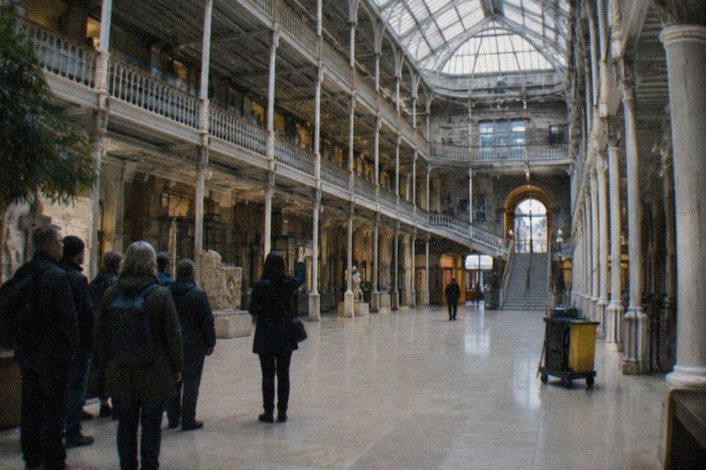 Light-filled museum atrium with ornate cast-iron galleries rising several storeys